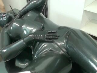 Encased en noir latex combinaison de chatte avec caoutchouc masque et breathplay masturbation